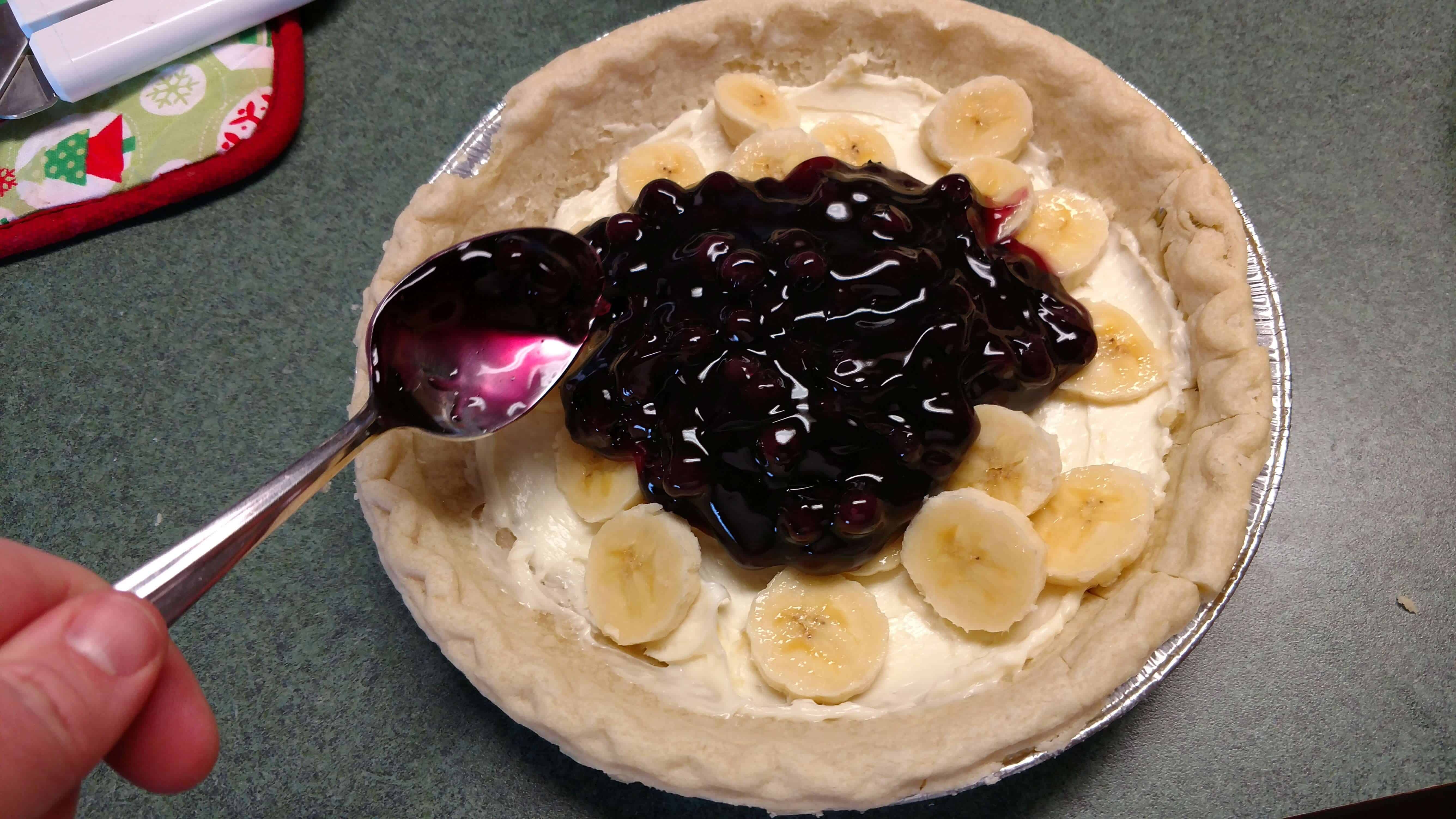 Spreading blueberry pie filling on top of cream cheese filling