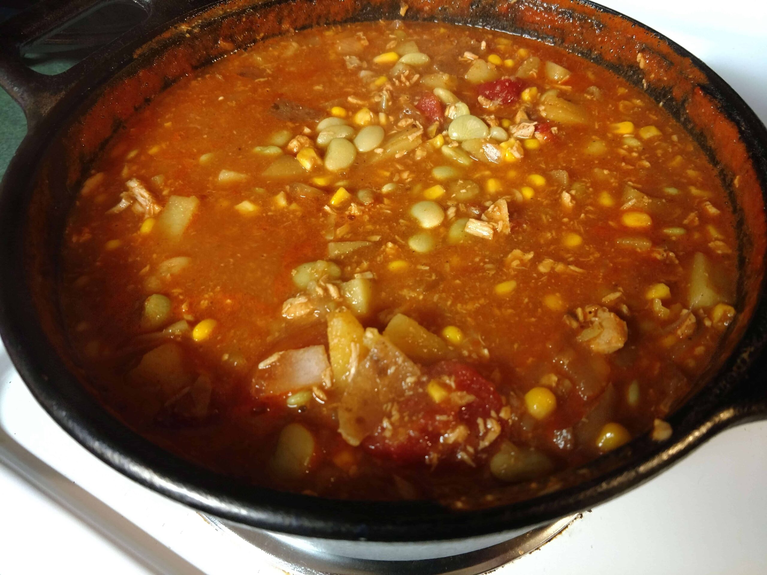 This image shows a pot of Brunswick Stew in a cast iron Dutch oven.
