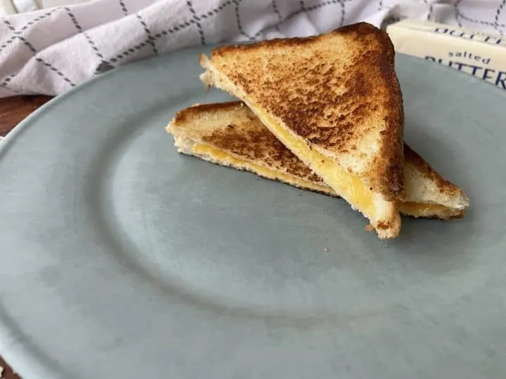 crispy golden brown grilled cheese stacked on a plate
