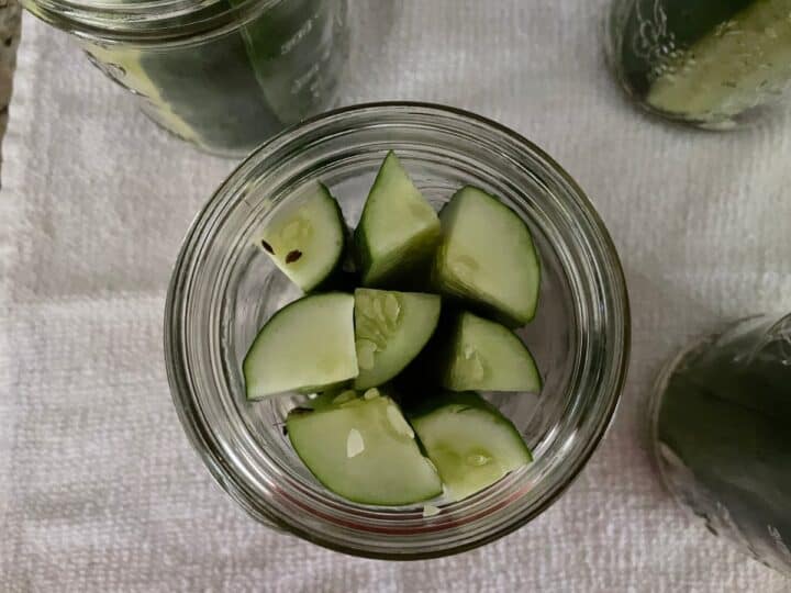 over head view of cucumber spears packed into ball canning jar.
