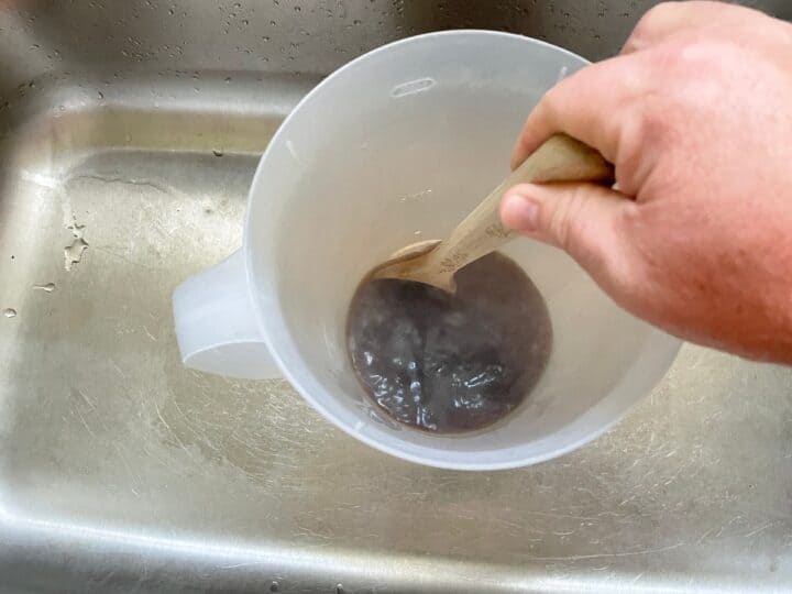 mixing hot tea in tea pitcher to dissolve sugar.
