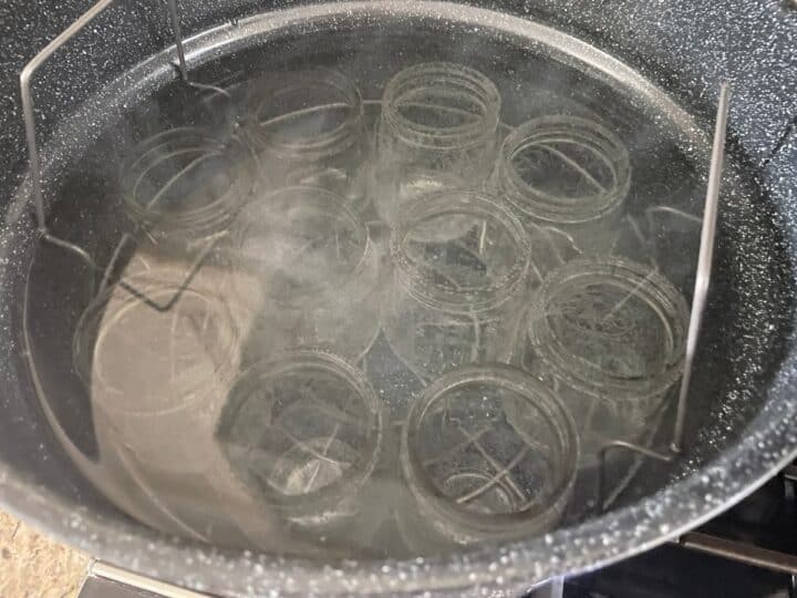 mason jars sterilizing in a water bath canner that will be used to make dill pickles.