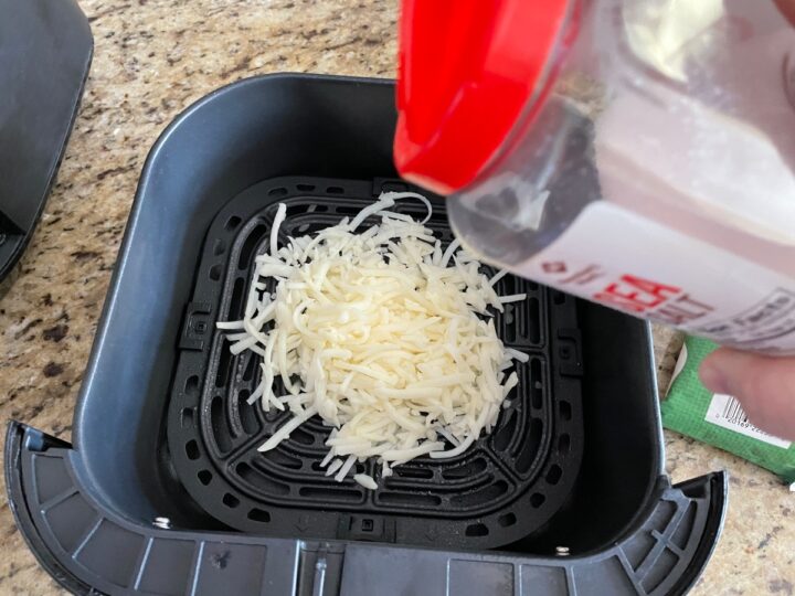 adding salt to shredded hash browns before cooking in the air fryer.