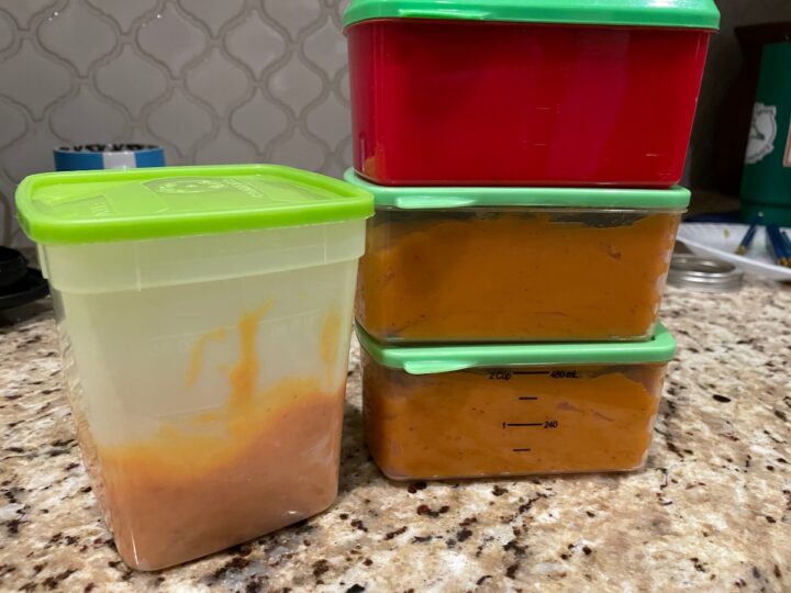 Persimmon puree divided in to 2-cup portions in freezer safe containers ready to go in the freezer for storage.