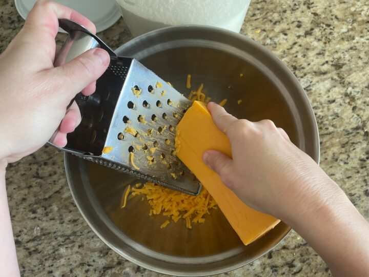 Grating sharp cheddar cheese for making.