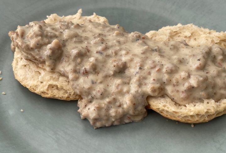 Closeup Shot of home made sausage gravy on a homemade biscuit.