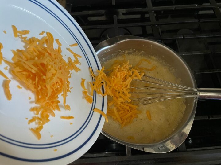 adding sharp cheddar cheese to stone ground grits.
