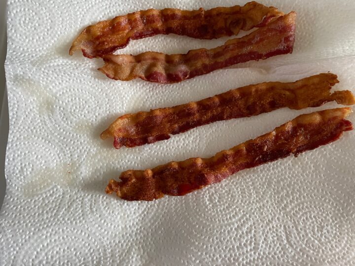 fried bacon cooling off on paper towels.