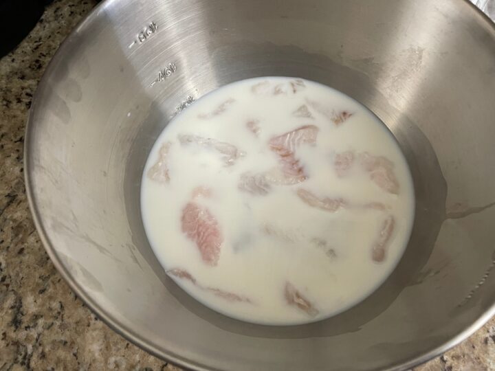 Catfish nuggets soaking in milk.