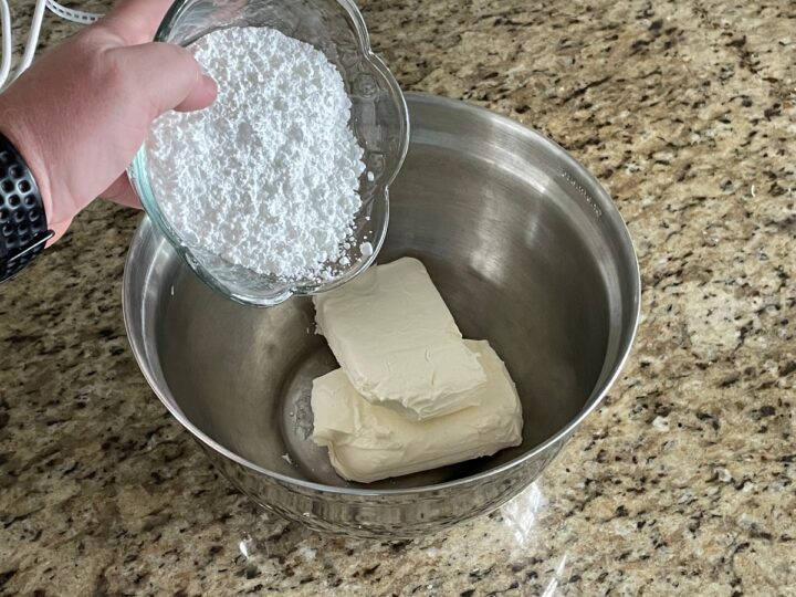 adding confectioners sugar to cream cheese.