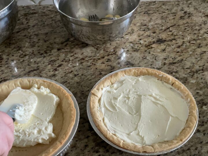 spreading cream cheese base in pie shells.