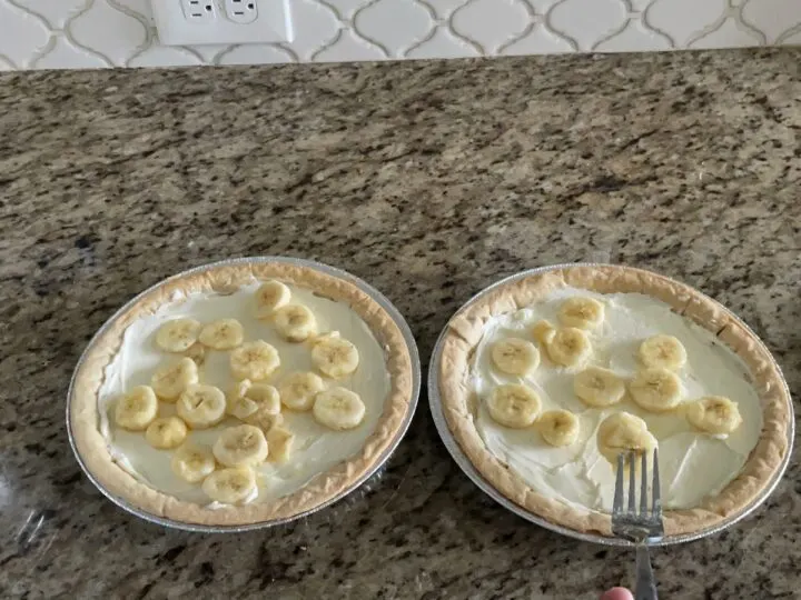 adding banana slices to the cream cheese base.