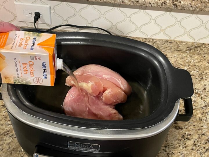 adding chicken broth to crock pot.