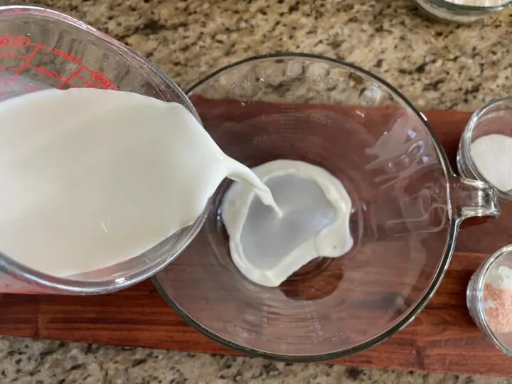 adding milk to a mixing bowl.