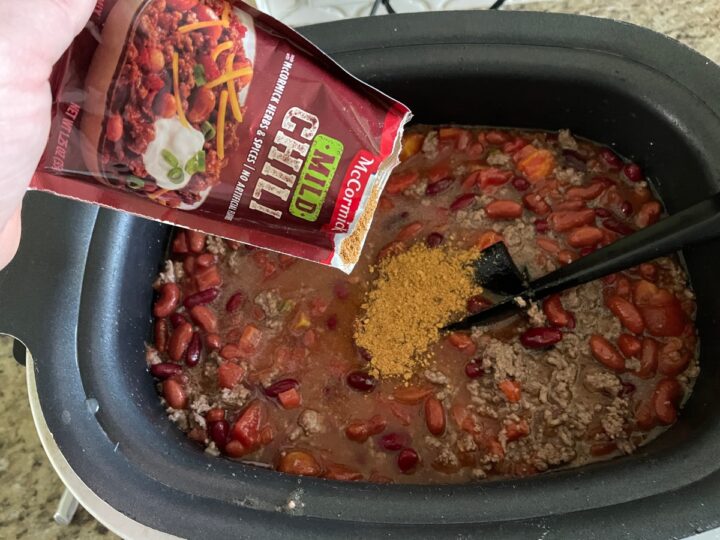 adding in McCormick seasoning to the slow cooker.