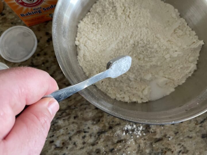 Adding baking powder to flour. 
