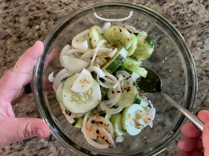 Mixing up dressing with the onions and cucumbers.