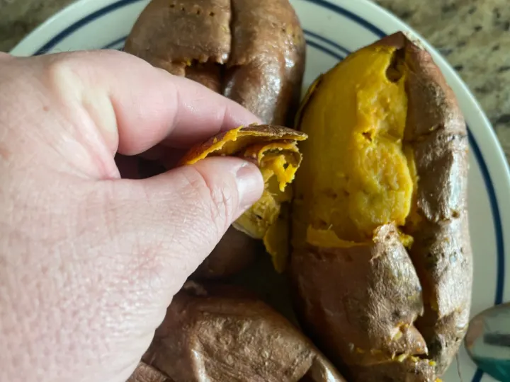 Peeling the skin off of the sweet potatoes. 