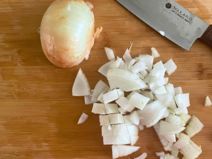 Chopping a sweet onion up to add to southern style green beans.