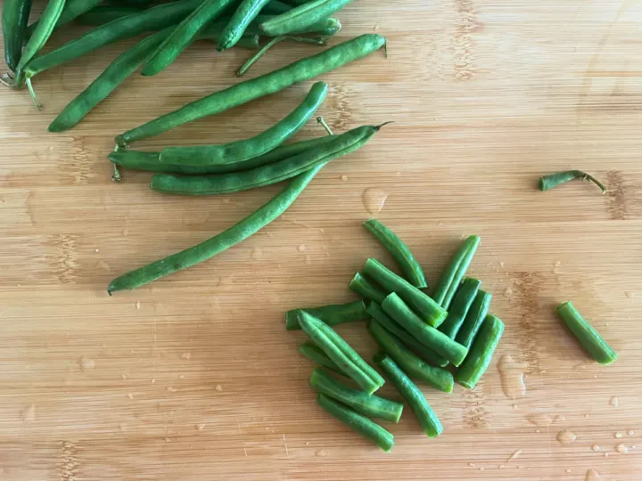 Cutting green beans into 2 inches sections for green bean recipe.