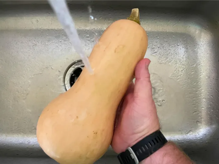 Washing the outside skin on the nutty squash before cooking it.