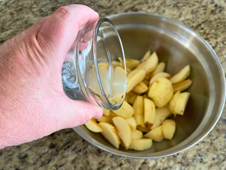 Adding lemon juice to apples.