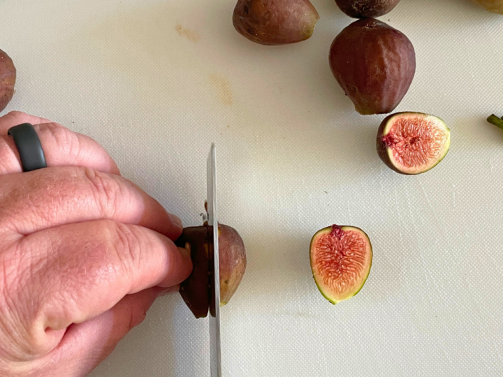 This is a picture of a closer view of me cutting the fresh figs in half. 