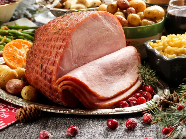 Picture from Canva showing the smoked ham being in the center of a holiday feast. 