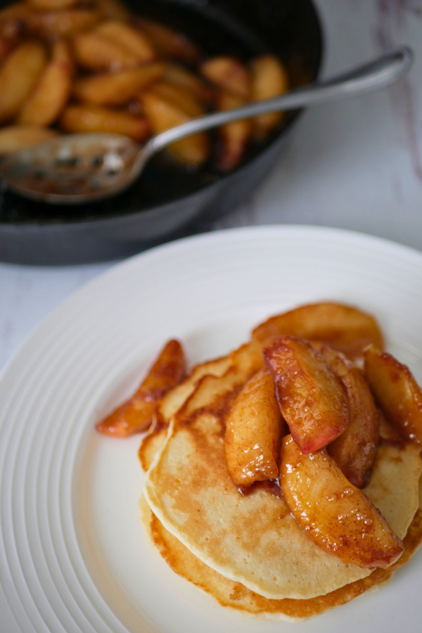 This is a image of southern fried apples on top of old fashioned pancakes.