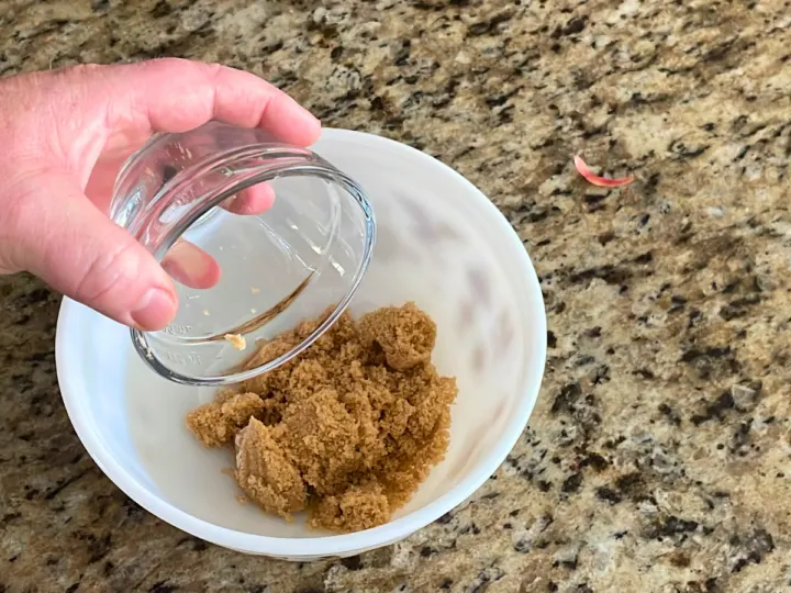 This image shows adding brown sugar to a bowl to make fried apples.