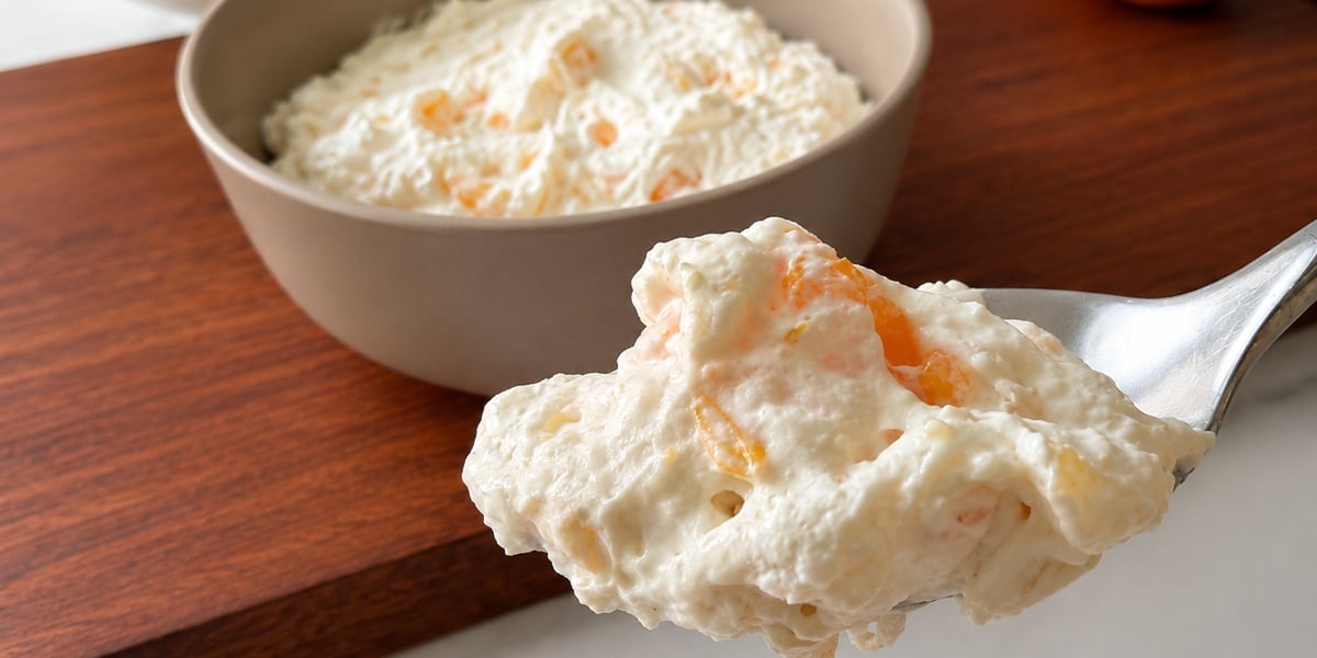 Close-up spoonful of creamy fruit fluff dessert.