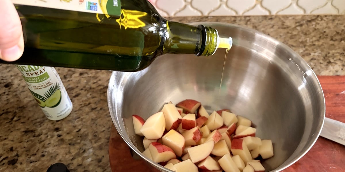 Olive oil and seasoning added to diced red potatoes