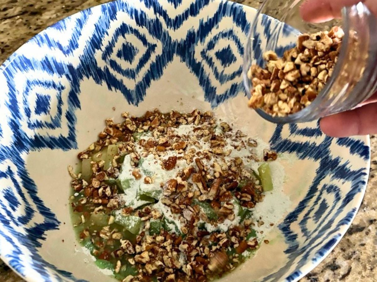 Adding chopped pecans to the pineapple and pistachio pudding mixture for Watergate Salad.