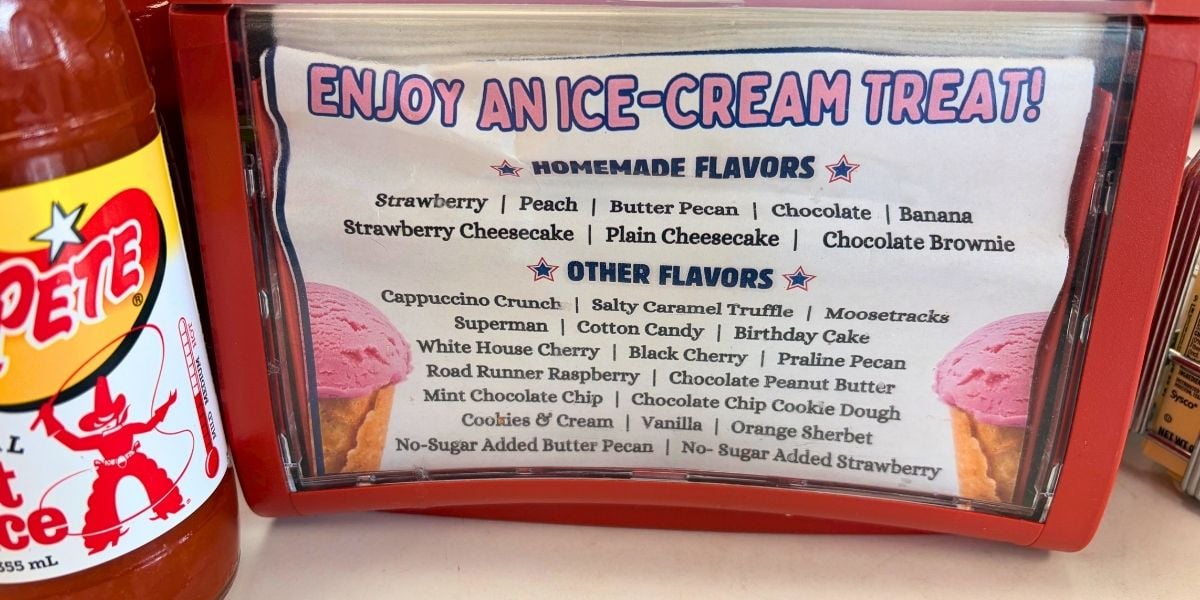 A napkin holder menu insert displaying homemade ice cream flavors like strawberry and peach at Strawberry Hill USA Cafe and Ice Cream Parlor in Chesnee, South Carolina.