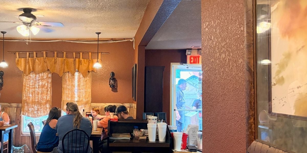 Dining room inside Haywood Smokehouse with tables and booths in the old-house restaurant
