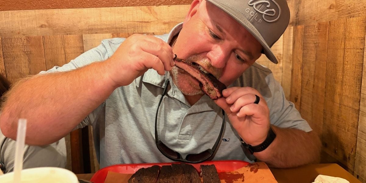 Taking a bite of a dry-rubbed rib during our visit to Haywood Smokehouse in Waynesville, NC