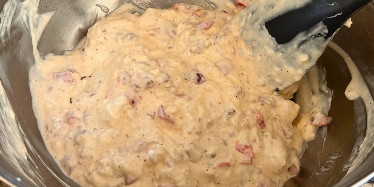 Cream cheese, mayonnaise, pimentos, bacon, and seasonings mixed in a bowl.